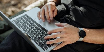 person in black zip up jacket using laptop